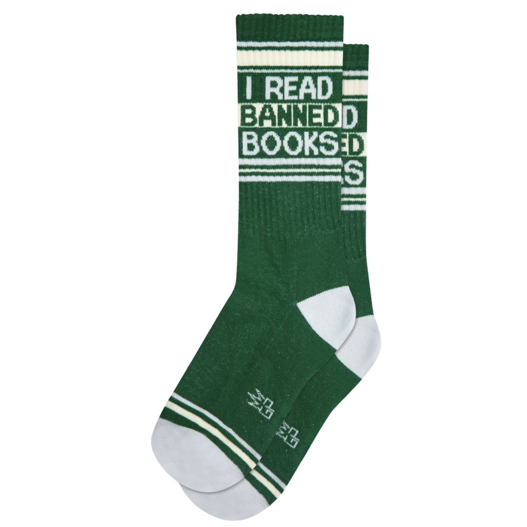 Green socks with white stripes and text "I Read Banned Books". Take a break and slip into these cushioned socks to discover the books the Man doesn't want you to read. Constructed with 61% Cotton, 36% Nylon, and 3% Spandex, these socks are proudly made in the USA.